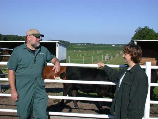 The vet with the farmer in front of the fence